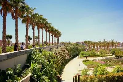 a walkway with palm trees in a park at Parc Central Mint Apartment in Valencia