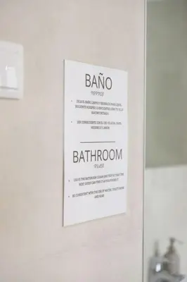 a sign hanging on a wall in a bathroom at Habitación Cardenal 1 in Valencia
