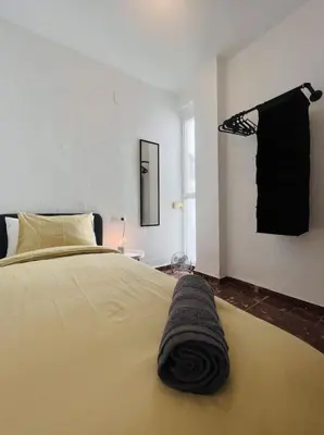 a bedroom with a bed with a black blanket on it at Habitación Cardenal 1 in Valencia