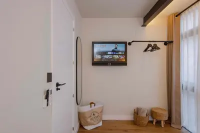a television on the wall of a room with a refrigerator at Apartamento acogedor frente a Mercat Central in Valencia