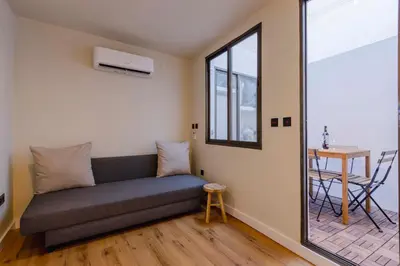 a couch in a room with a window and a table at Apartamento acogedor frente a Mercat Central in Valencia
