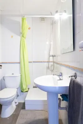 a white bathroom with a toilet and a sink at Habitación Cardenal 2 in Valencia