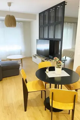 a living room with a table and yellow chairs at Marques de Caro Rooms Luxury in Valencia