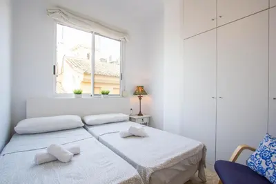 a white bedroom with a bed and a window at Valencia central apartment in Valencia
