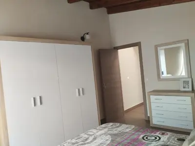 a bedroom with a bed and a dresser and a mirror at Casa Bonaire in Chella