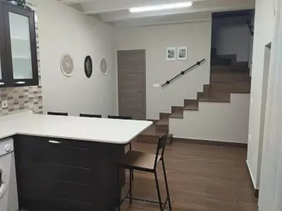 a room with a staircase with a counter and chairs at Casa Bonaire in Chella