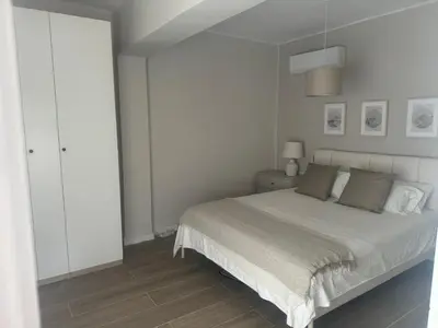 a white bedroom with a bed and a white cabinet at Ca Maruja in Cullera