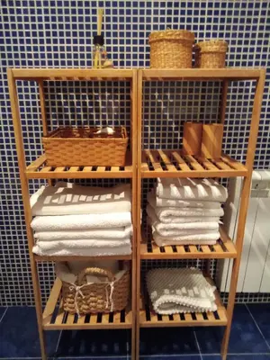 a towel rack with towels and baskets in a bathroom at Cozy flat in old town in Valencia