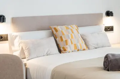 a white bed with pillows on top of it at Suite Deluxe Valencia - Ciudad de las Artes in Valencia
