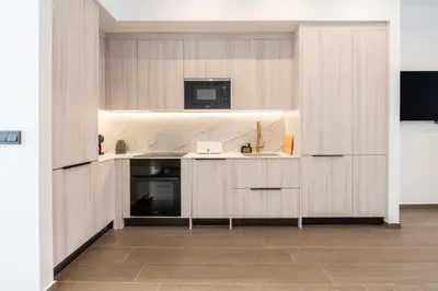 a kitchen with wooden cabinets and a microwave at Suite Deluxe Valencia - Ciudad de las Artes in Valencia