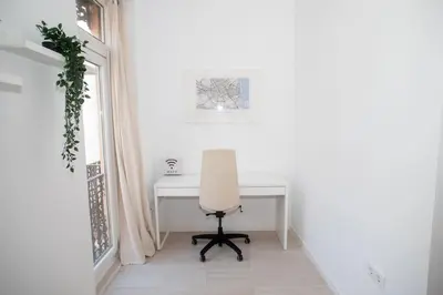 a white desk in a white room with a chair at Apartamento acogedor frente a Torres de Serrano in Valencia