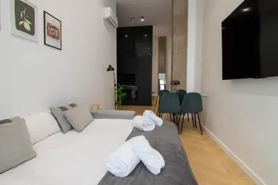 a living room with a white couch and a television at Luxe Appartement in Valencia - Dichtbij strand in Valencia
