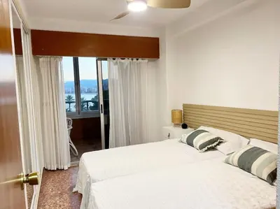 a bedroom with a large white bed with a window at Florazar 2 Apartamento frente al mar en Cullera in Cullera