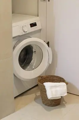 a washing machine and a basket of towels in a bathroom at Stylish apartment near Old town & Turia park in Valencia