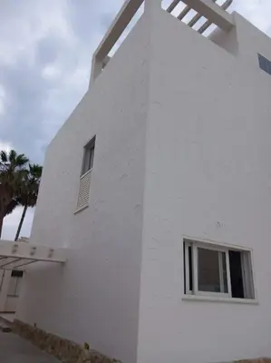 a white building with a window on the side of it at Chalet frente al Mar in Cullera
