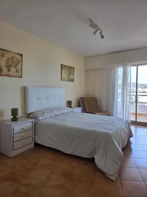 a bedroom with a bed with an orange blanket at Apartamento frente a la playa in Cullera