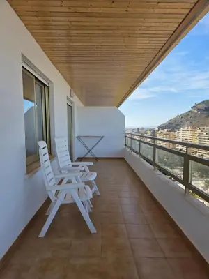 a bedroom with a white bed and a painting on the wall at Apartamento frente a la playa in Cullera