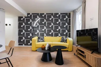 a living room with a yellow couch and a table at Smartr Valencia Turia in Valencia