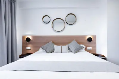 a bedroom with a bed with two mirrors on the wall at Smartr Valencia Turia in Valencia