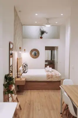 a bedroom with a bed and a table with chairs at Nuevo y moderno loft en amistat in Valencia