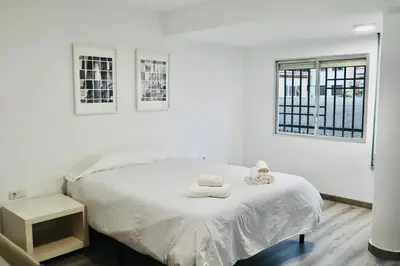 a white bedroom with a bed with towels on it at Big Flat Ruzafa in Valencia