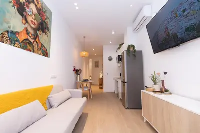 a living room with a white couch and a large painting on the wall at Apartment Casa Novi - Close to Beach, City Center & Metro in Valencia