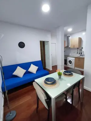 a living room with a blue couch and a table at Benimaclet Deluxe3 in Valencia