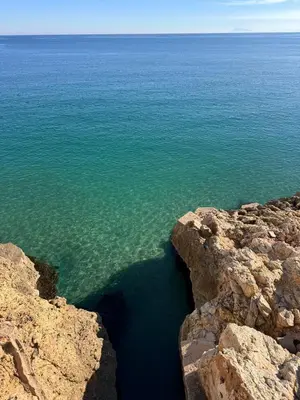 a view of the ocean from between rocks at Arena apartment in Faro de Cullera