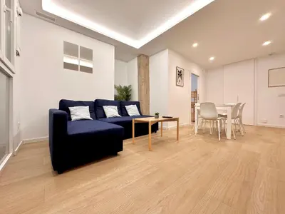 a living room with a blue couch and a table at Apartamento Hierros VLC in Valencia