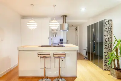 a kitchen with a counter with a sink and some stools at Loft Valencia centro - Vive el corazón de la ciudad in Valencia