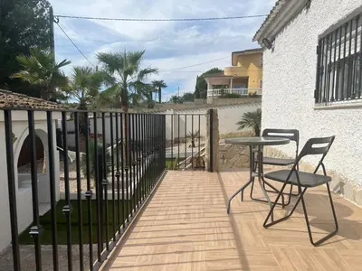 a balcony with a table and chairs and a fence at Villa con piscina en la montaña in Llombay