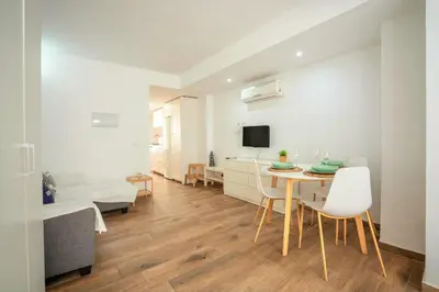 a living room with a table and chairs and a tv at Apto 2 P Ferrandis in Valencia