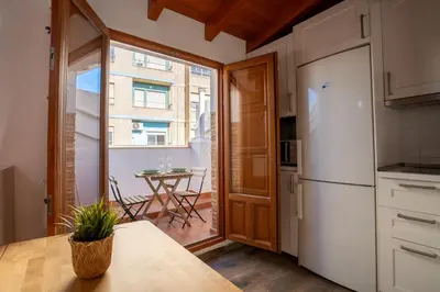 a kitchen with a white refrigerator and a table at Apto 3 P Ferrandis in Valencia