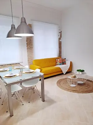 a living room with a table and a yellow couch at Loft DobleAltura Escalante in Valencia