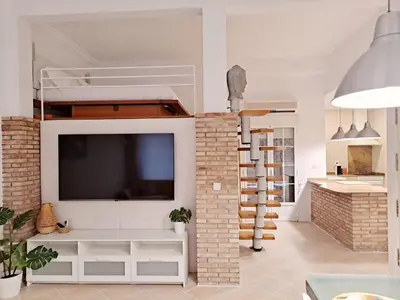 a living room with a tv and a loft bed at Loft DobleAltura Escalante in Valencia