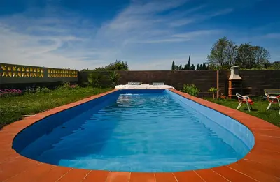 a large swimming pool in a yard with a patio at Valencia Autentica, Casa Rural 
