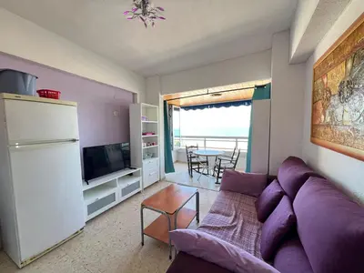 a living room with a purple couch and a table at El Prado - Primera Línea Playa Cullera in Valencia