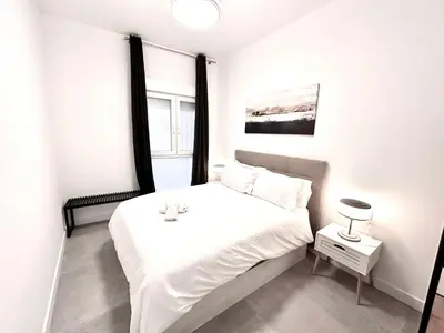 a white bedroom with a white bed and a window at Convenient, Charming Apartment 15 Mins from City Center in Valencia