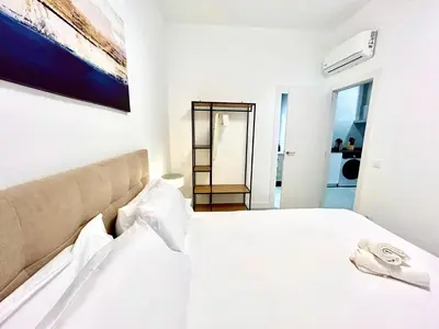 a white bedroom with a large white bed at Convenient, Charming Apartment 15 Mins from City Center in Valencia