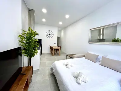 a bedroom with a large white bed and a clock on the wall at Valencia Urban Escape Comfort Meets Luxury, 4 Ppl in Valencia