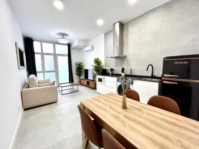 a kitchen and living room with a wooden table in a room at Valencia Urban Escape Comfort Meets Luxury, 4 Ppl in Valencia