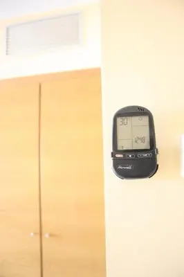 an alarm clock on a wall next to a cabinet at Ohmyloft Valencia in Burjasot