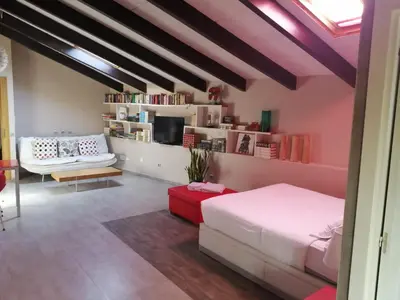 a bedroom with a bed and a living room at Apartamento Gutenberg in Valencia