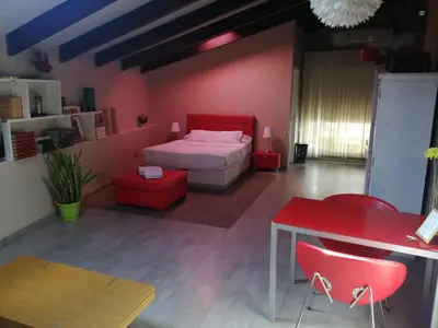 a bedroom with a bed and a red table and chairs at Apartamento Gutenberg in Valencia