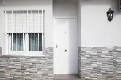 a white door and a window on a brick wall at District Key - Carricola in Valencia