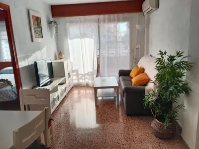 a living room with a couch and a tv at Los Olivos BB1 in Faro de Cullera