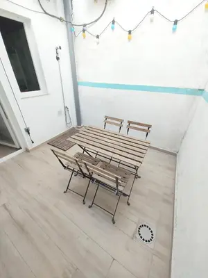 two benches and a table in a room at Maravillosa casa junto al mar y cerca del centro in Valencia