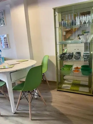 a dining room with a table and green chairs at Maravillosa casa junto al mar y cerca del centro in Valencia