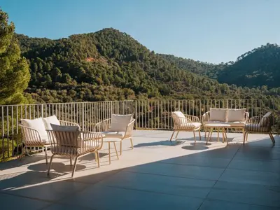a group of chairs and tables on a balcony with mountains at Alojamiento Rural 1Respiro Parque Natural Serra Calderona in Serra