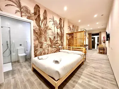 a bedroom with a large bed and a bathroom at Lofts Casa Tropicana in Valencia